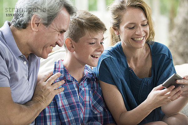 Familie betrachtet Smartphone zusammen