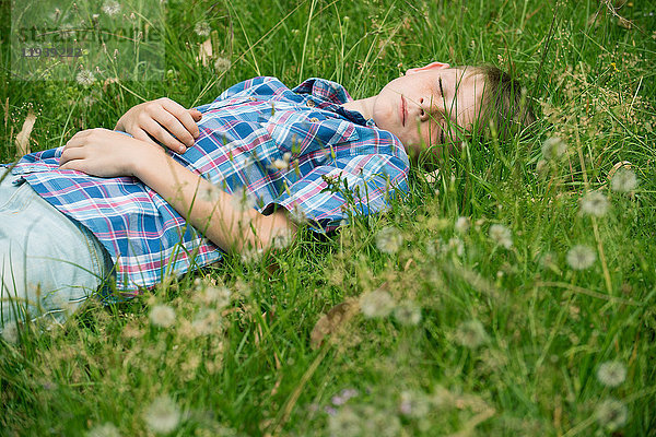 Junge schläft auf Gras