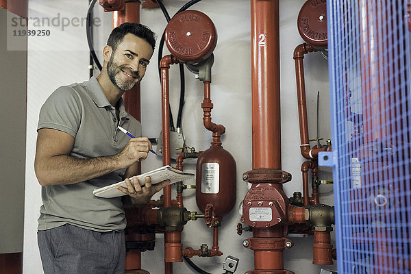Mann inspiziert Brandschutz-Sprinkleranlage