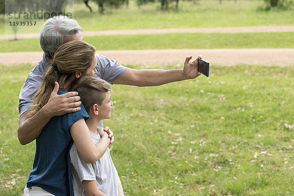 Familie posiert für einen Selfie im Freien