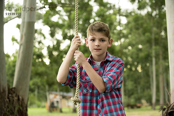 Junge auf Seilschaukel  Portrait
