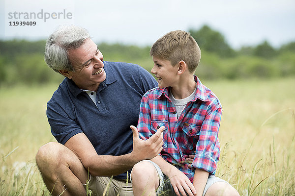 Großvater und Enkel beim Kleben im Freien