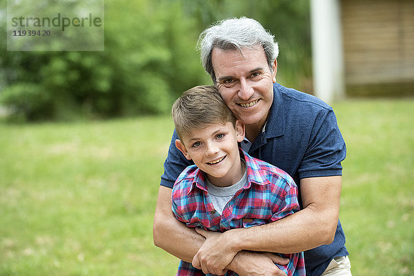 Großvater umarmt Enkel im Freien  Portrait
