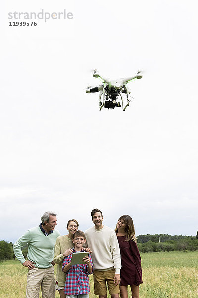 Familie spielt mit Drohne im Feld