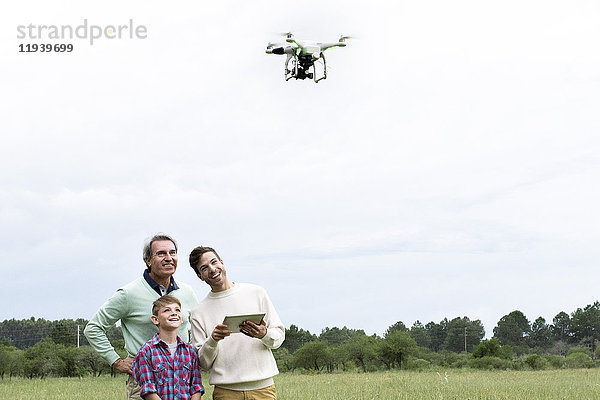 Familie mit digitalem Tablett zur Steuerung von Drohnen im Freien