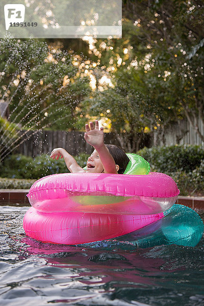 Junges Mädchen  das inmitten von aufblasbaren Ringen im Freibad steht