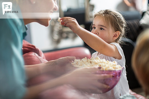 Mädchen  das Mutterpopcorn füttert