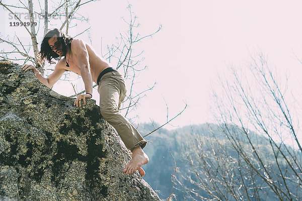 Männlicher Kletterboulderer mit nacktem Oberkörper und nacktem Fuss  Lombardei  Italien