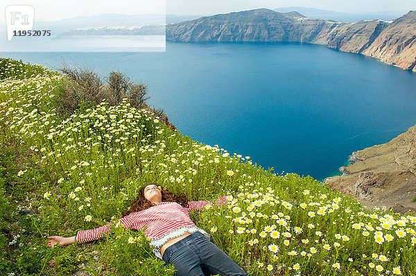 Mädchen schläft auf einem Blumenbeet  Oía  Santorini  Kikladhes  Griechenland