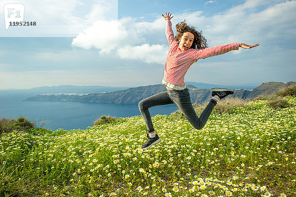 Mädchen  das über Blumen springt  Oía  Santorin  Kikladhes  Griechenland