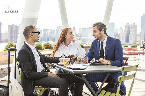 Geschäftsleute treffen sich im Hafencafé mit der Skyline von New York  USA