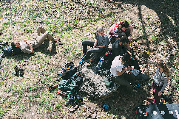 Blick von oben auf erwachsene Boulderfreunde  die sich auf Gras entspannen  Lombardei  Italien