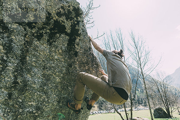 Junge männliche Boulderer klettern Boulder  Lombardei  Italien