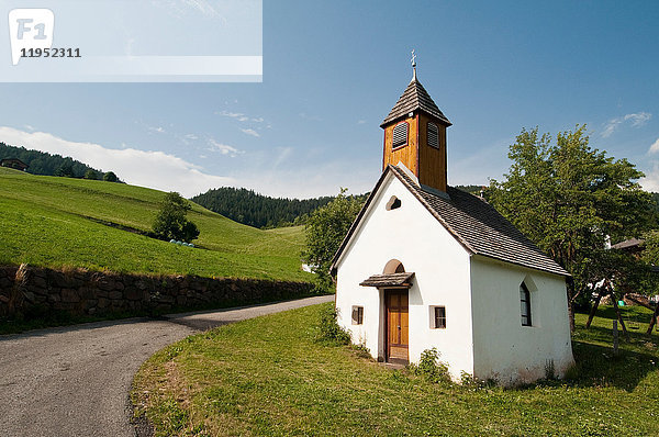 Landstraße und Kirche San Pietro  Tal von Funes  Dolomiten  Italien