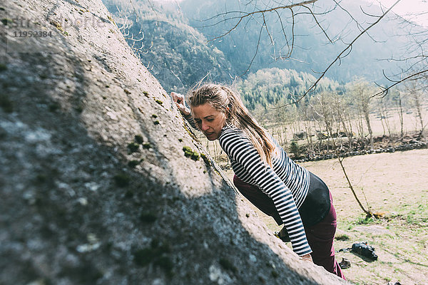 Junge weibliche Bouldererin beim Klettern am Boulder  Lombardei  Italien