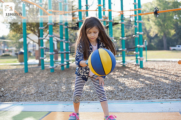 Mädchen hüpft Basketball auf dem Spielplatz