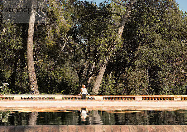 Weibliche Touristin schaut seitwärts am See im Labyrinth-Park von Horta  Barcelona  Spanien