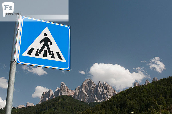 Schild für Fußgängerübergang über die Odle Mountains und den blauen Himmel  Tal von Funes  Dolomiten  Italien