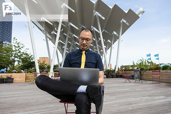 Geschäftsmann mit Laptop vor einem Hotel  New York  USA