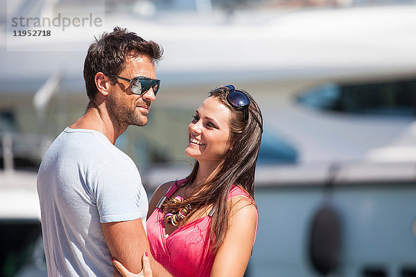 Paar steht am Hafen  umarmt sich  lächelt