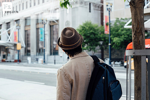 Junger Mann beim Spaziergang im Freien  Rucksack tragend  Rückansicht