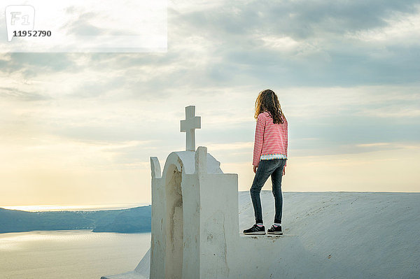 Mädchen oben auf der Kirche stehend  Oía  Santorini  Kikladhes  Griechenland