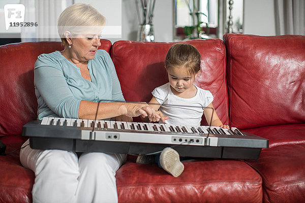 Mädchen und Großmutter spielen Keyboard