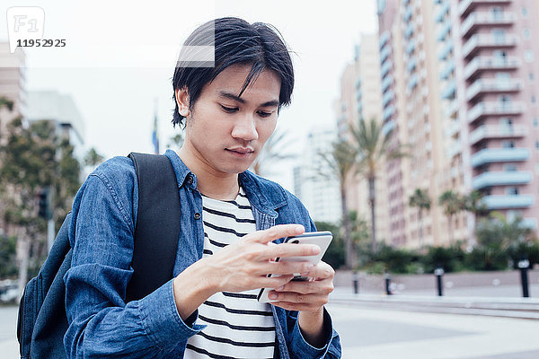 Junger Mann im Freien  benutzt Smartphone