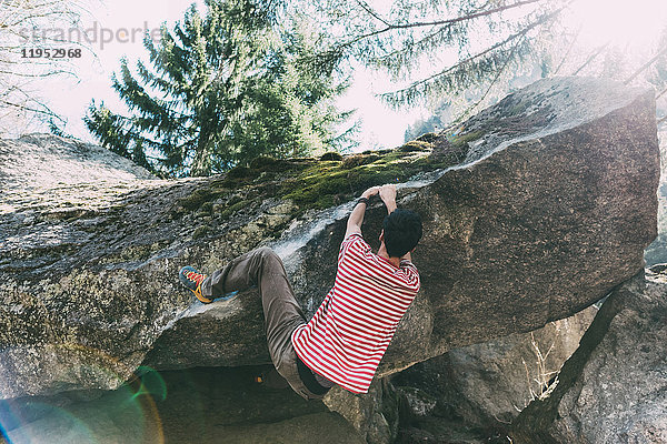 Männlicher Boulderer klettert Boulderüberhang  Lombardei  Italien