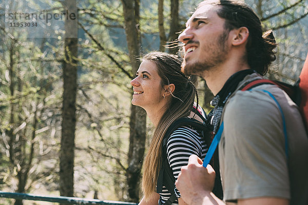 Zwei junge erwachsene Wanderer schauen im Wald nach oben  Lombardei  Italien