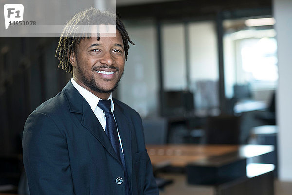 Porträt eines jungen Geschäftsmannes im Amt  lächelnd