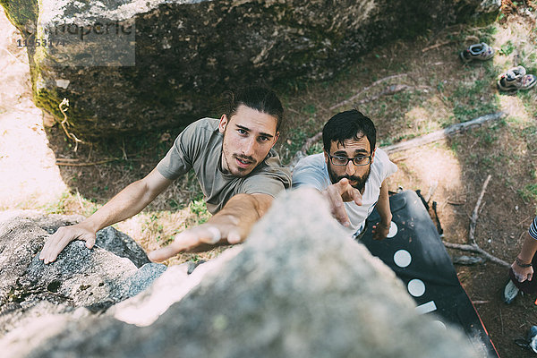 Hochwinkelaufnahme von Männern beim Klettern von Felsbrocken  Lombardei  Italien