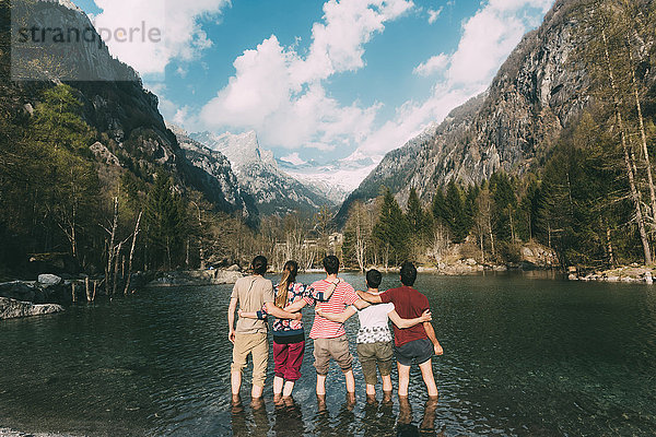 Rückansicht von fünf erwachsenen Freunden knöcheltief im Bergsee  Lombardei  Italien