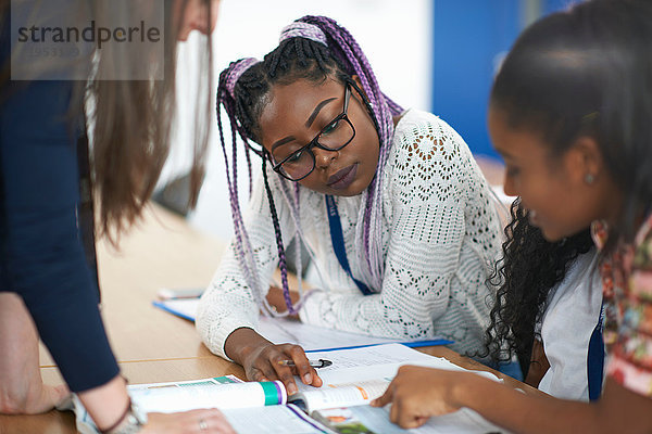 Lehrer im Klassenzimmer hilft Schülern beim Lernen