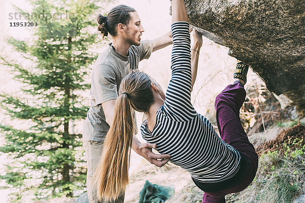 Junger männlicher Boulderer unterstützt Frau beim Bouldern  Lombardei  Italien