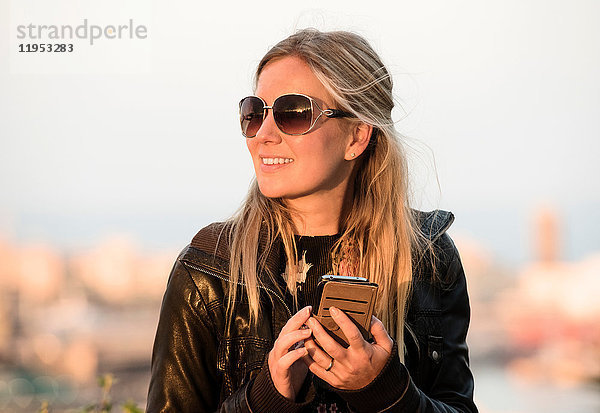 Blondhaarige Touristin mit Smartphone in der Hand  Barcelona  Spanien