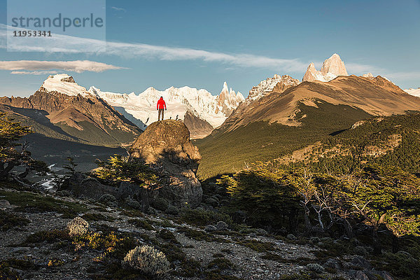 Männlicher Wanderer mit Blick auf den Cerro Torre und die Fitz Roy-Gebirgskette im Los Glaciares-Nationalpark  Patagonien  Argentinien