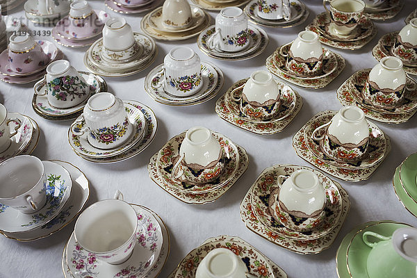 Hochwinkel-Nahaufnahme einer großen Anzahl von Teetassen und Untertassen mit verschiedenen Blumenmustern.