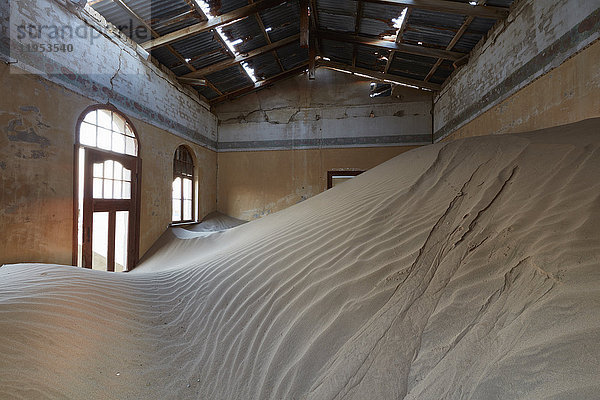 Ein Blick auf ein Zimmer in einem heruntergekommenen Gebäude voller Sand.