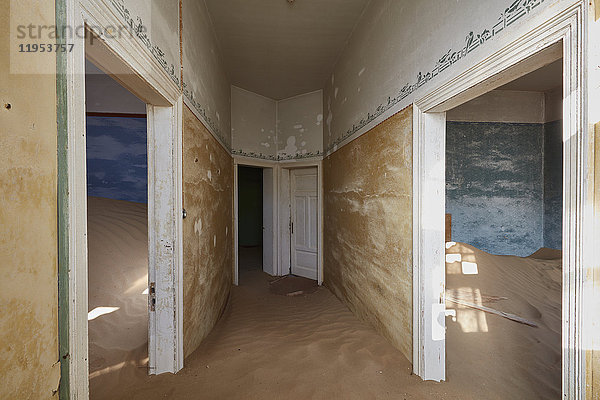 Ein Blick auf Räume in einem heruntergekommenen Gebäude voller Sand.