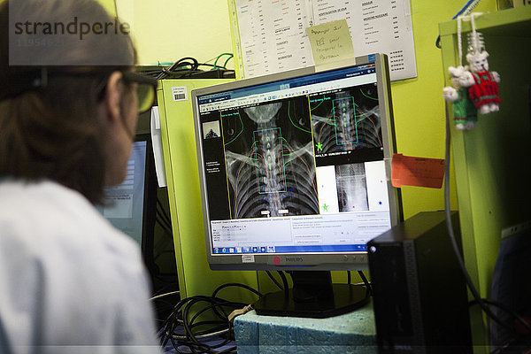 Reportage in der Strahlentherapieabteilung eines Krankenhauses in Savoie  Frankreich. Zwei Techniker überwachen die Bestrahlungssitzung. Behandlung von zervikalen und dorsalen Adenokarzinomen.