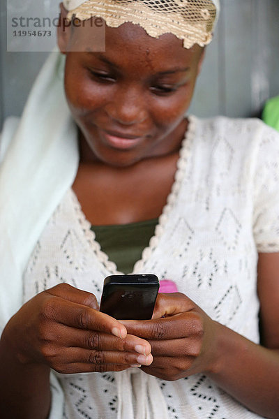 Afrikanische Frau bei der Benutzung eines Mobiltelefons. Lome. Togo.