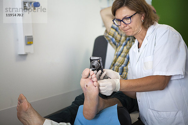 Reportage über die Fußsprechstunde für Diabetiker in einem Krankenhaus in Savoyen  Frankreich. Diese Beratungen werden von einem spezialisierten Team durchgeführt und sind der Behandlung und Nachsorge von Fußverletzungen bei Diabetikern gewidmet. Der Fußpfleger fotografiert die Wunde  um ihren Verlauf zu verfolgen.