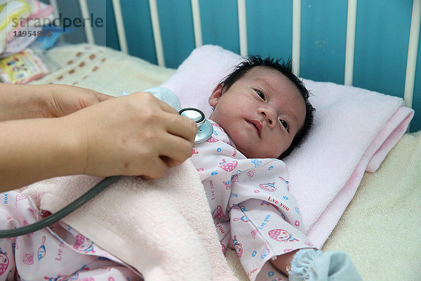 Das Herzinstitut bietet vietnamesischen Patienten  die an Herzkrankheiten leiden  eine hochwertige Versorgung. Ein Arzt hört das Herz eines kleinen Babys ab. Ho-Chi-Minh-Stadt. Vietnam.
