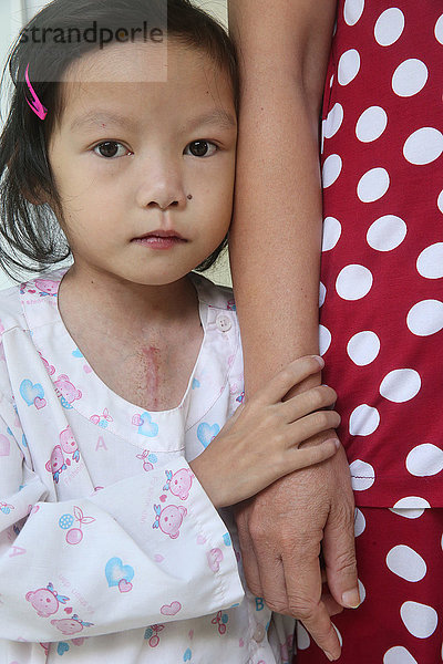 Das Herzzentrum bietet vietnamesischen Patienten  die an Herzkrankheiten leiden  eine hochwertige Versorgung. Mädchen mit Mutter. Ho-Chi-Minh-Stadt. Vietnam.