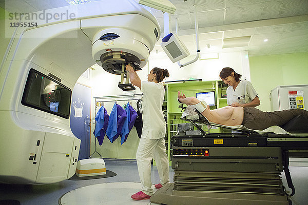 Reportage aus der Strahlentherapieabteilung eines Krankenhauses in Savoie  Frankreich. Zwei Techniker bereiten eine Patientin für eine Strahlentherapie zur Behandlung von Brustkrebs vor. Ein Elektronenortungsgerät wird eingesetzt  um eine zusätzliche Dosis auf der Oberfläche zu erzeugen. Diese Patientin wurde operiert  und einige Krebszellen können in dieses Gewebe einwandern.