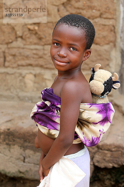 Afrikanisches Mädchen mit einem Kuscheltier. Togo.