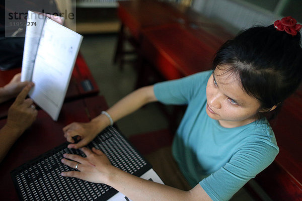 Vietnam. Zentrum für blinde Kinder. Mädchen schreibt Blindenschrift.
