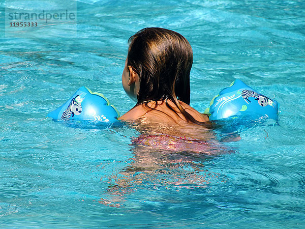 Ein Kind schwimmt in einem Pool.