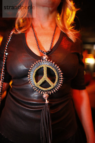 Frau trägt einen Anhänger mit Friedenssymbol. Frankreich.